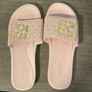 pink Michael Kors slides with gold flower detail